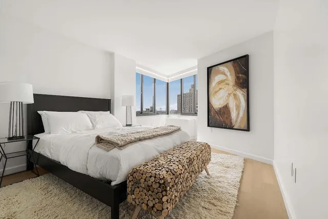 a bedroom with a bed and a painting on the wall