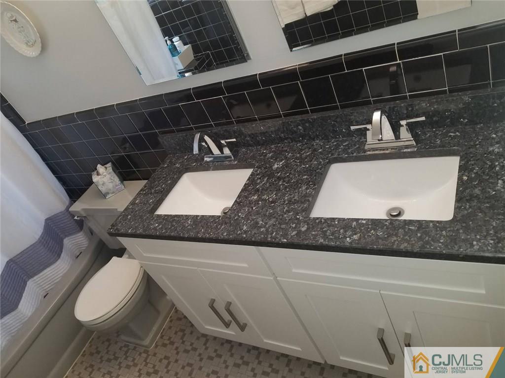 30 Agate Road East Brunswick, NJ 08816 - Photo 33 of 40 a bathroom with a granite countertop toilet sink and mirror