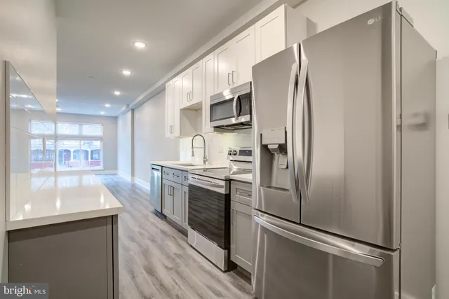 a kitchen with stainless steel appliances a refrigerator and a sink