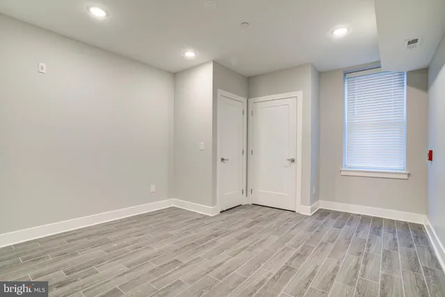 a view of an empty room with wooden floor