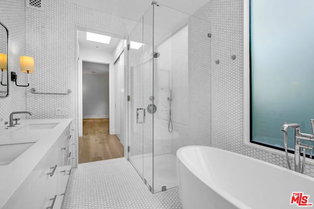 a bathroom with a tub sink and mirror