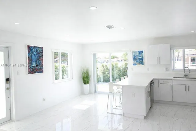 a kitchen with white cabinets and stainless steel appliances