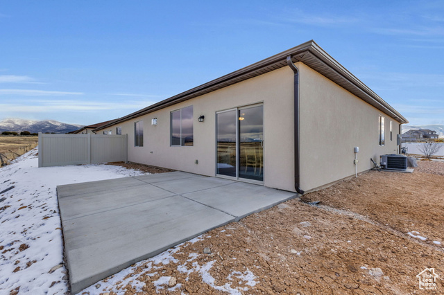 155 East 360th Street East, Unit 10B Fillmore, UT 84631 - Photo 30 of 43 Snow covered rear of property with a mountain view, a patio area, and central air condition unit
