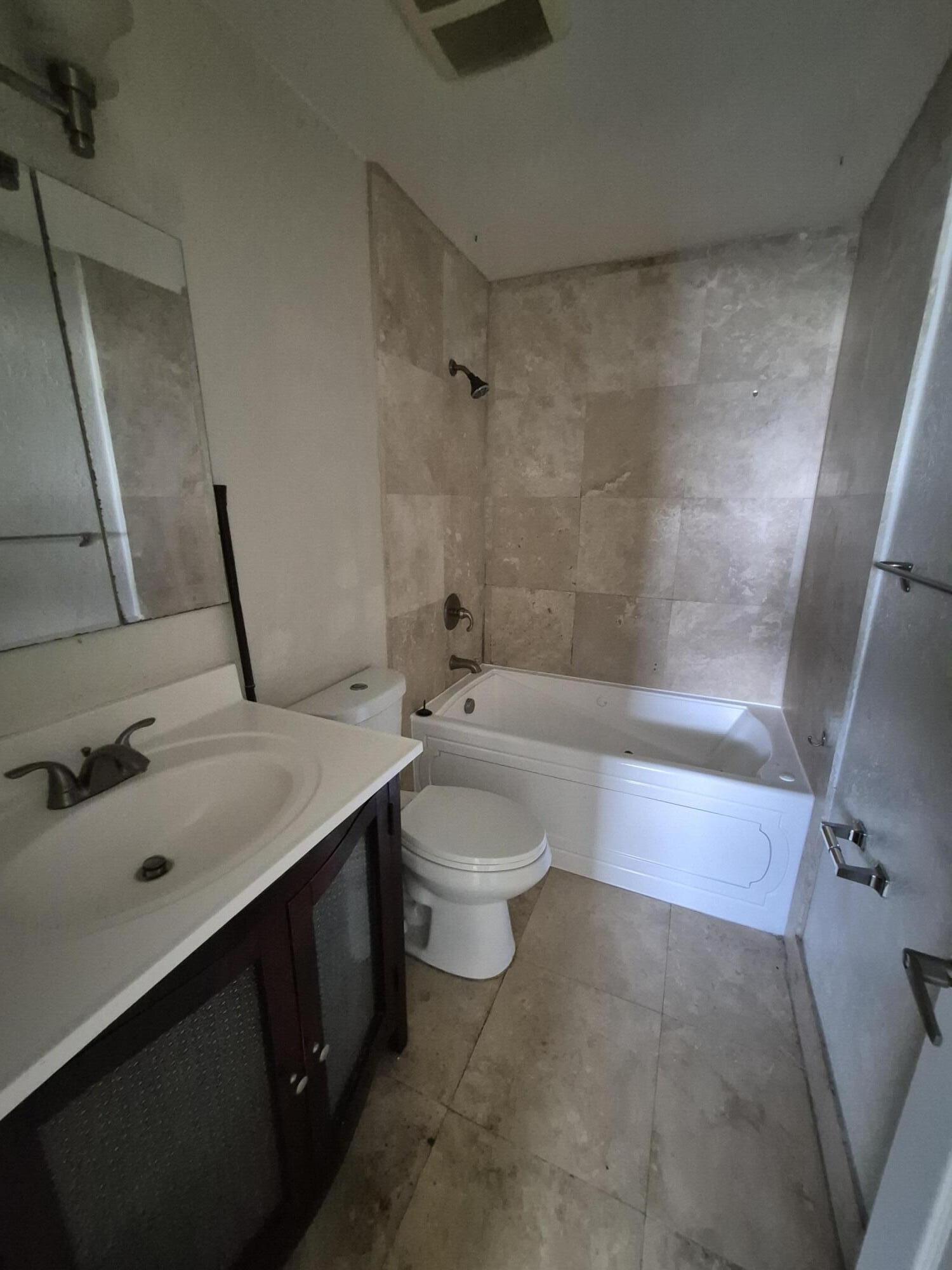 10039 Winding Lake Road, Unit 202 Sunrise, FL 33351 - Photo 9 of 14 a bathroom with a sink a toilet and shower