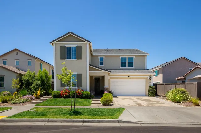 a front view of a house with a yard and garage
