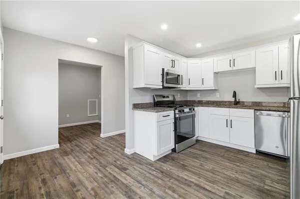 a kitchen with stainless steel appliances a stove top oven and a refrigerator