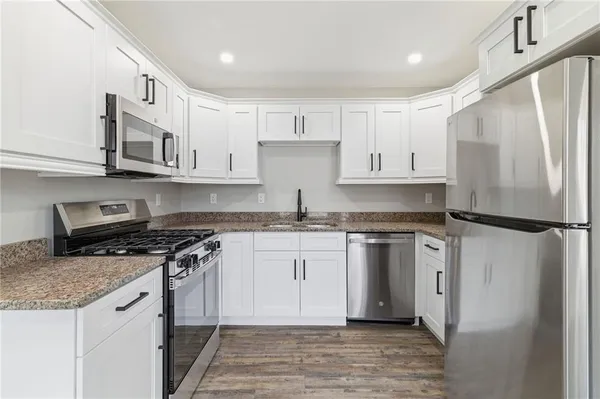 a kitchen with stainless steel appliances granite countertop a refrigerator sink and stove