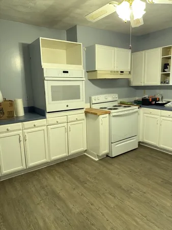 a kitchen with cabinets a sink and white stainless steel appliances