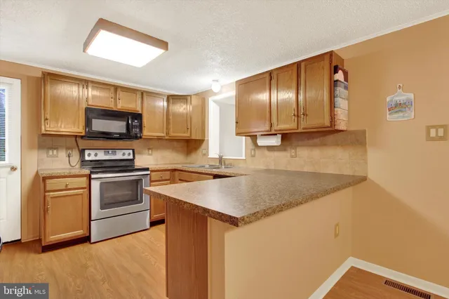 a kitchen with stainless steel appliances granite countertop a sink microwave and stove