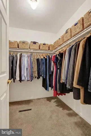 a view of walk in closet with clothes