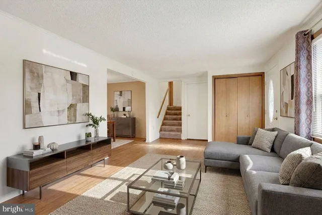 a living room with furniture and wooden floor