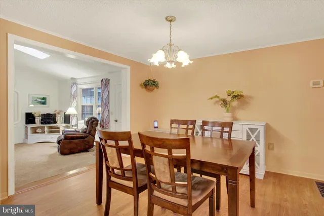 a view of a dining room with furniture wooden floor and chandelier