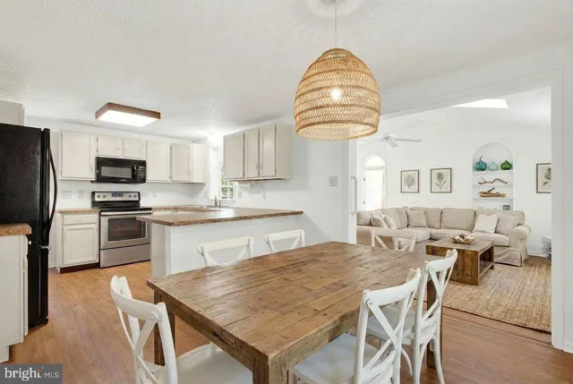 a kitchen with stainless steel appliances granite countertop a kitchen island a stove a table and chairs