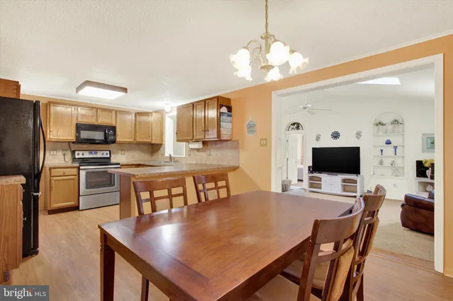 a large kitchen with a table chairs stainless steel appliances and cabinets