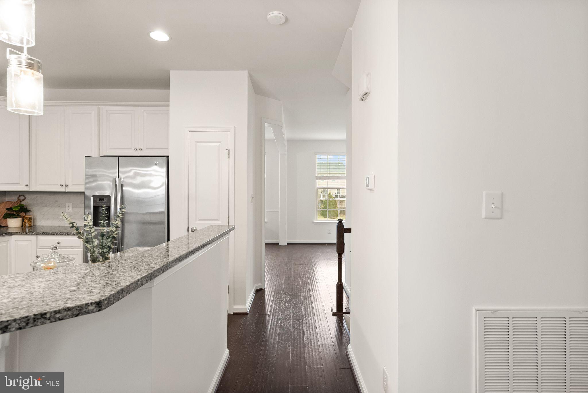 13671 Rockingham Lane Gainesville, VA 20155 - Photo 16 of 45 a kitchen with stainless steel appliances granite countertop a refrigerator a sink and white cabinets