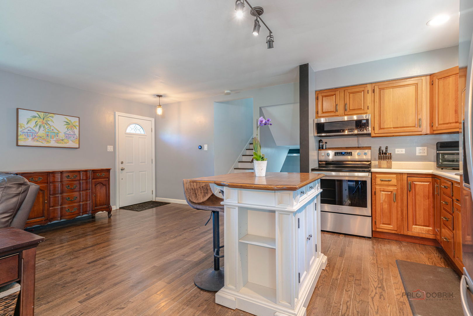 489 1st Street Antioch, IL 60002 - Photo 11 of 33 a kitchen with stainless steel appliances kitchen island wooden floors and white cabinets
