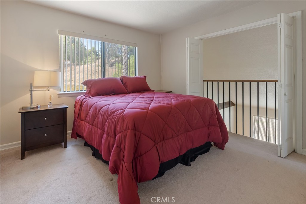 17656 Mockingbird Hill Circle Riverside, CA 92504 - Photo 16 of 49 a bed sitting in a bedroom next to a window