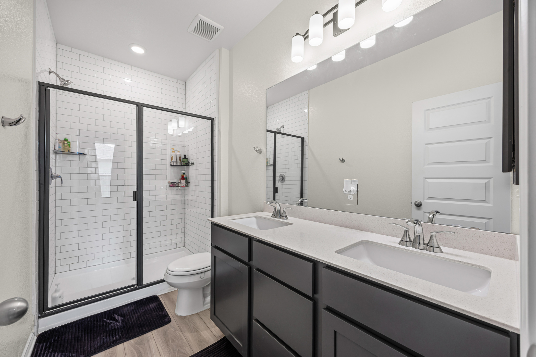 222 Summit Drive Lockhart, TX 78644 - Photo 15 of 31 a bathroom with a double vanity sink toilet mirror and shower