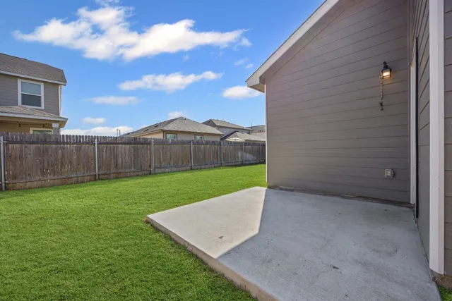 a view of a backyard with wooden fence