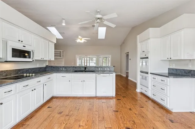 a view of an entryway with wooden floor and a ceiling fan