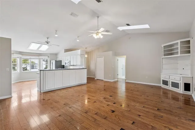 a view of a kitchen with a fridge wooden floor and a kitchen