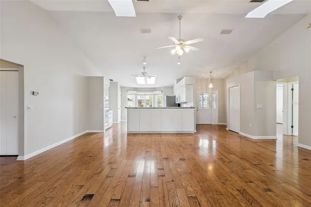 a kitchen with stainless steel appliances granite countertop a stove a sink dishwasher and a refrigerator with wooden floor