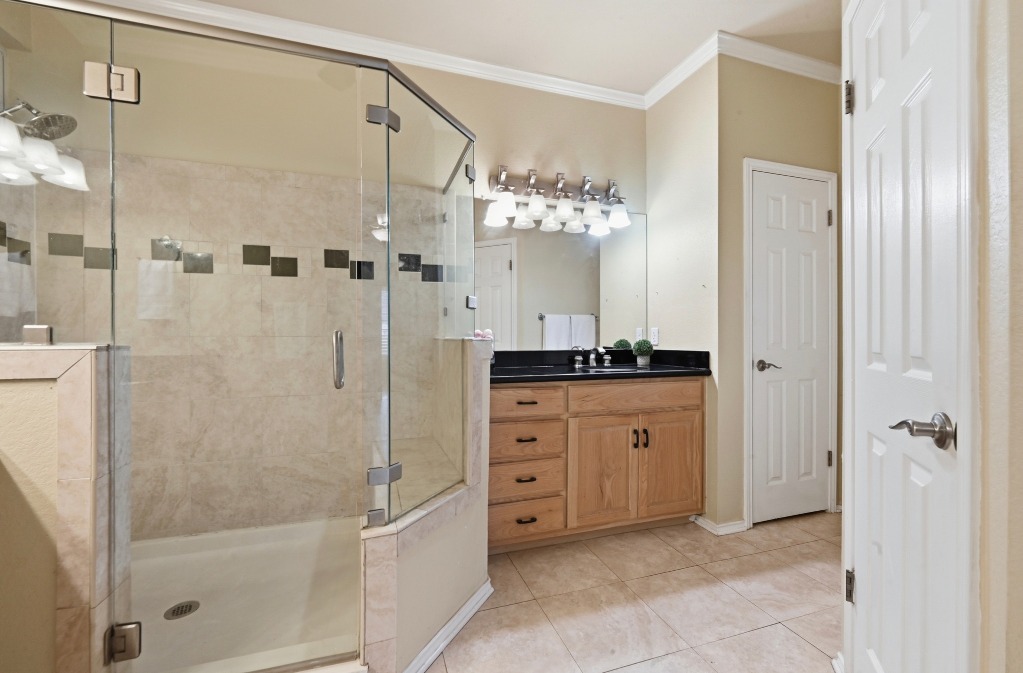 5313 Moon Shadow Drive Austin, TX 78735 - Photo 23 of 30 Bathroom featuring a glass-enclosed shower with tile surround, a built-in shower bench, and decorative accent tiles