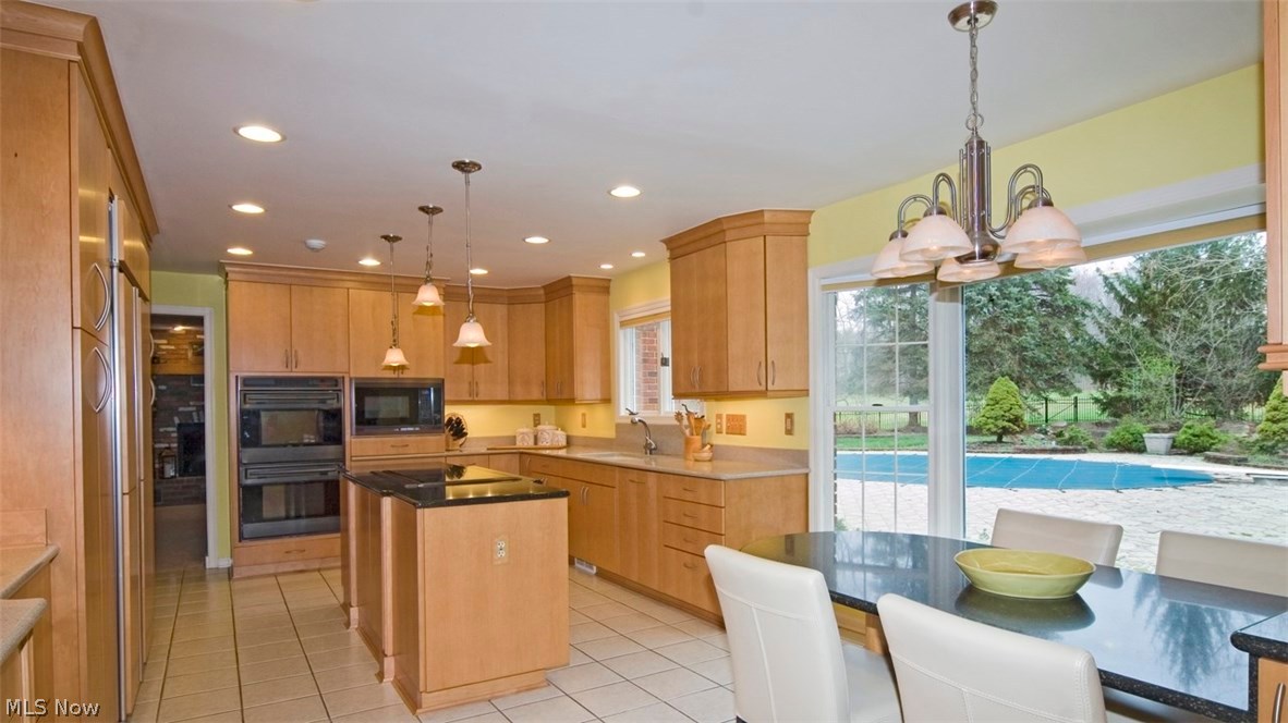 13419 County Line Road Chesterland, OH 44026 - Photo 5 of 21 Enjoy the view of the pool and back yard from the built-in kitchen table. The spacious kitchen features double Wolf ovens, built-in microwave and even a coffee bar, at left.