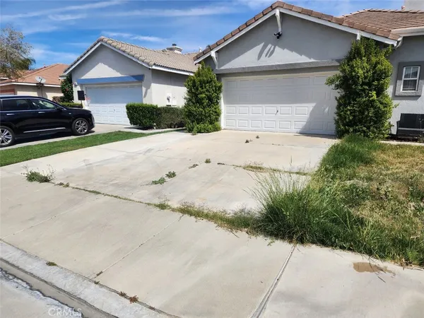 a view of house with a yard and parking space