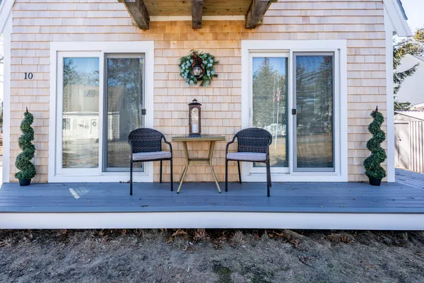 a view of a deck with table and chairs with wooden floor and plants