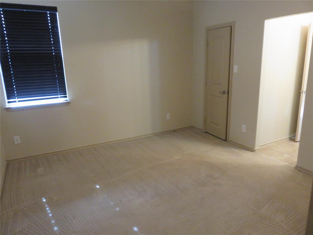 1122 Walter Stephenson Road Midlothian, TX 76065 - Photo 21 of 26 Carpeted room featuring a window with horizontal blinds, a panel door with a silver handle, and light-colored walls