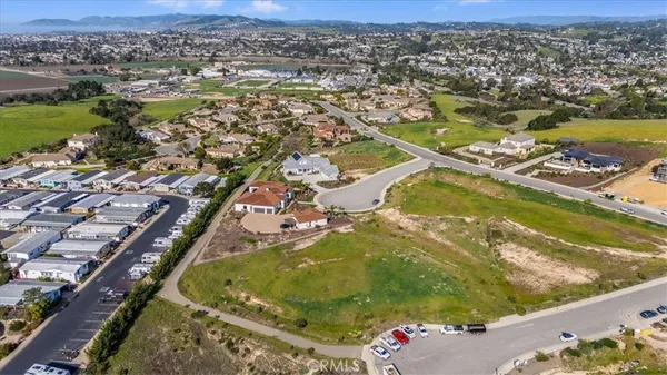 an aerial view of a swimming pool with a yard and mountain view