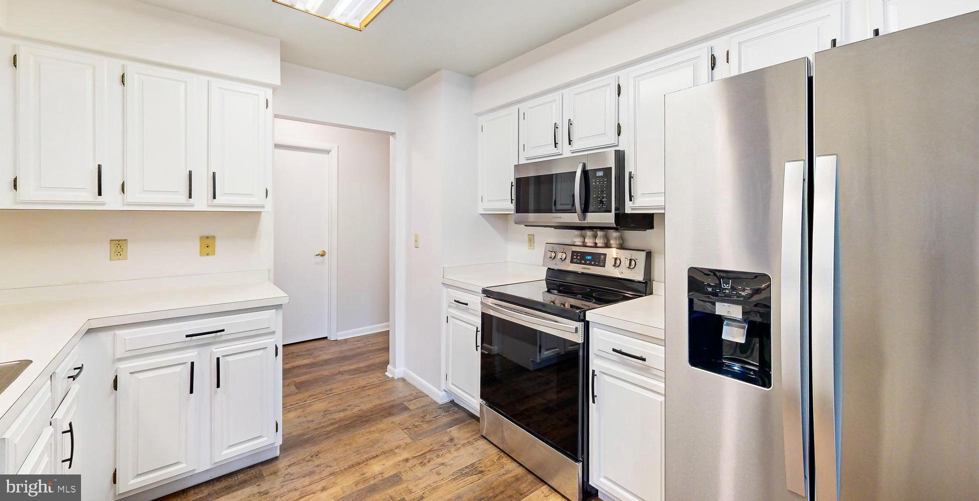 33945 Middleton Circle, Unit 1 Lewes, DE 19958 - Photo 11 of 45 a kitchen with white cabinets and stainless steel appliances