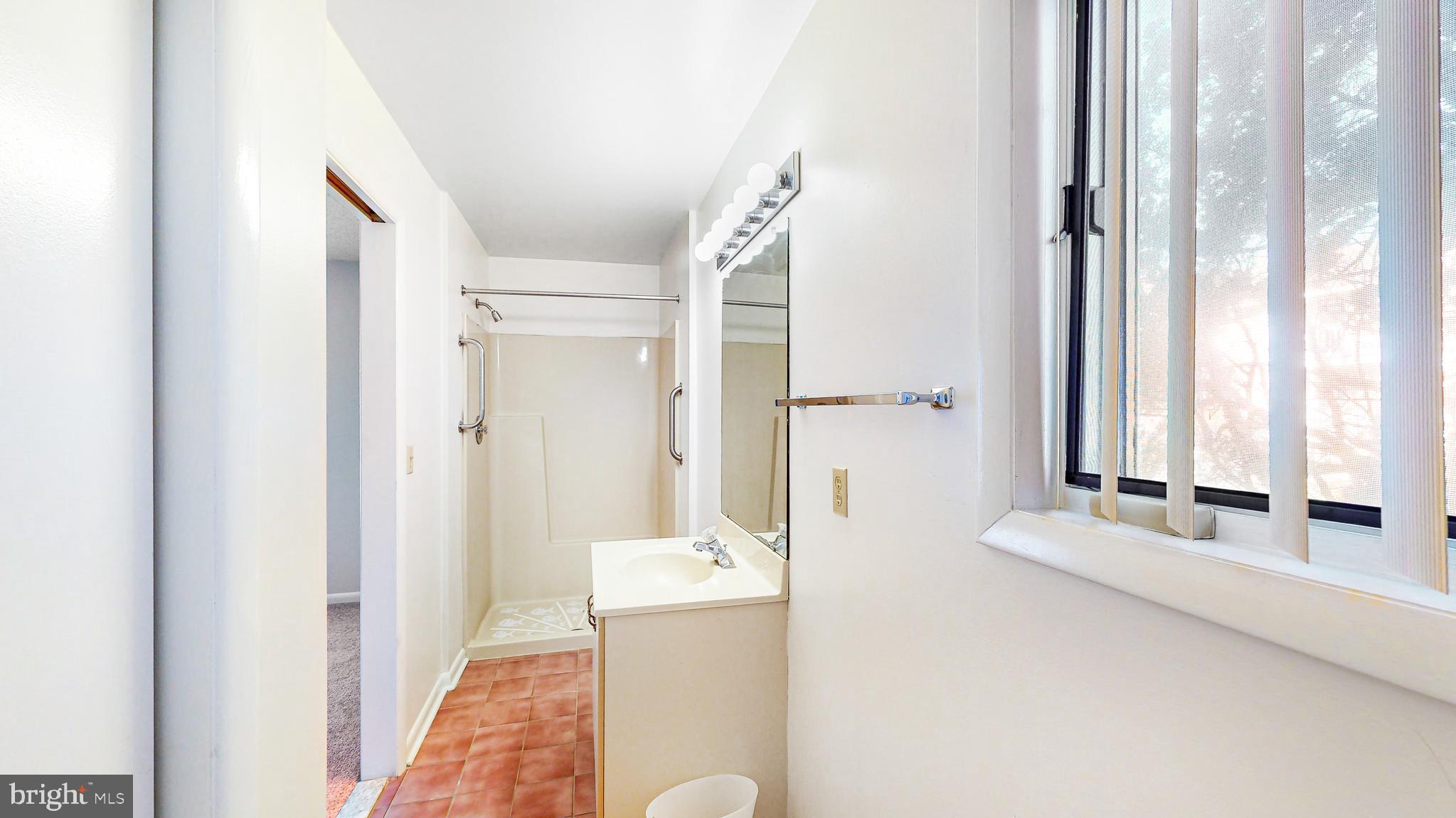 33945 Middleton Circle, Unit 1 Lewes, DE 19958 - Photo 23 of 45 a bathroom with a tub shower and window