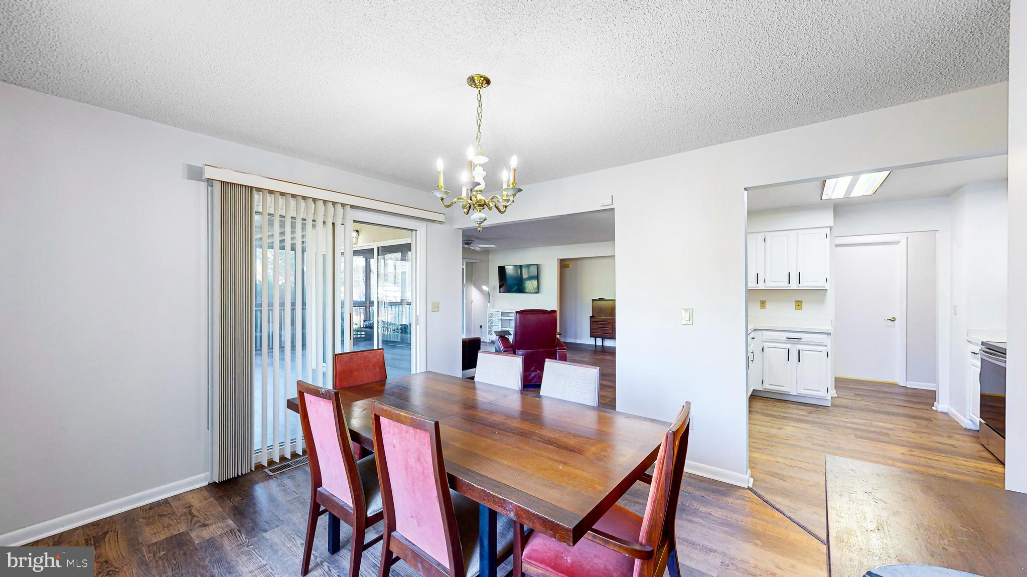 33945 Middleton Circle, Unit 1 Lewes, DE 19958 - Photo 3 of 45 a dining room with furniture a chandelier and wooden floor