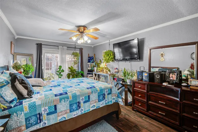 a bedroom with a bed table and flat screen tv