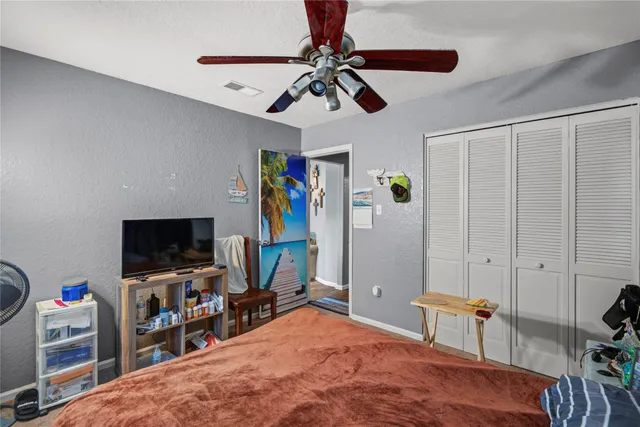 a bedroom with a bed and a flat tv screen on the dresser