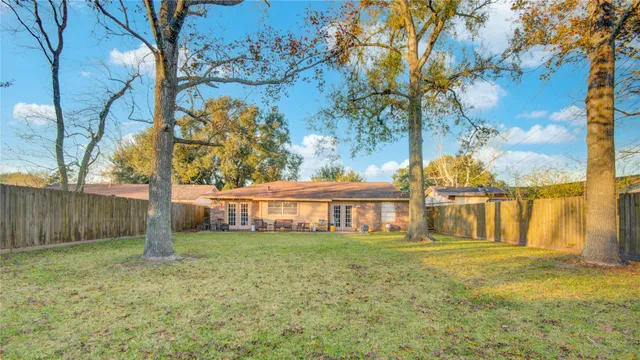 a view of a house with backyard and a tree