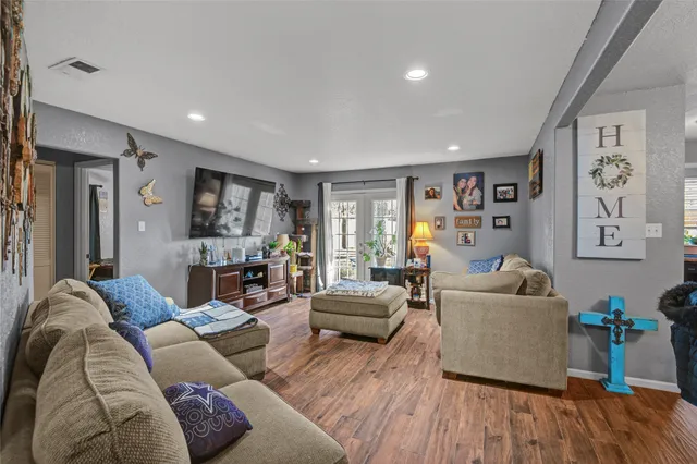 a living room with furniture and a wooden floor