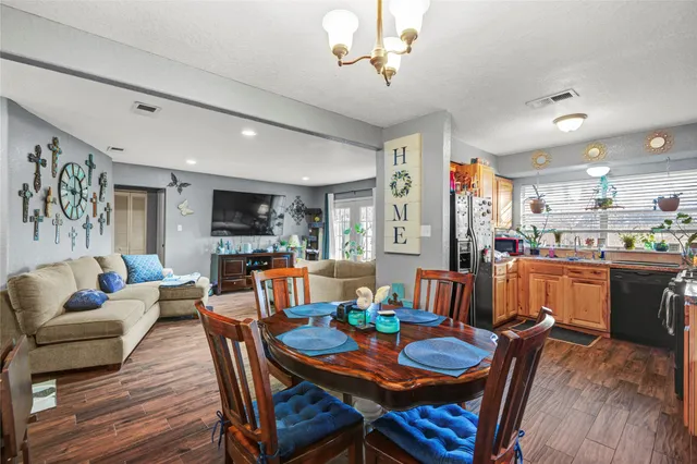 a dining room with furniture a kitchen view and wooden floor