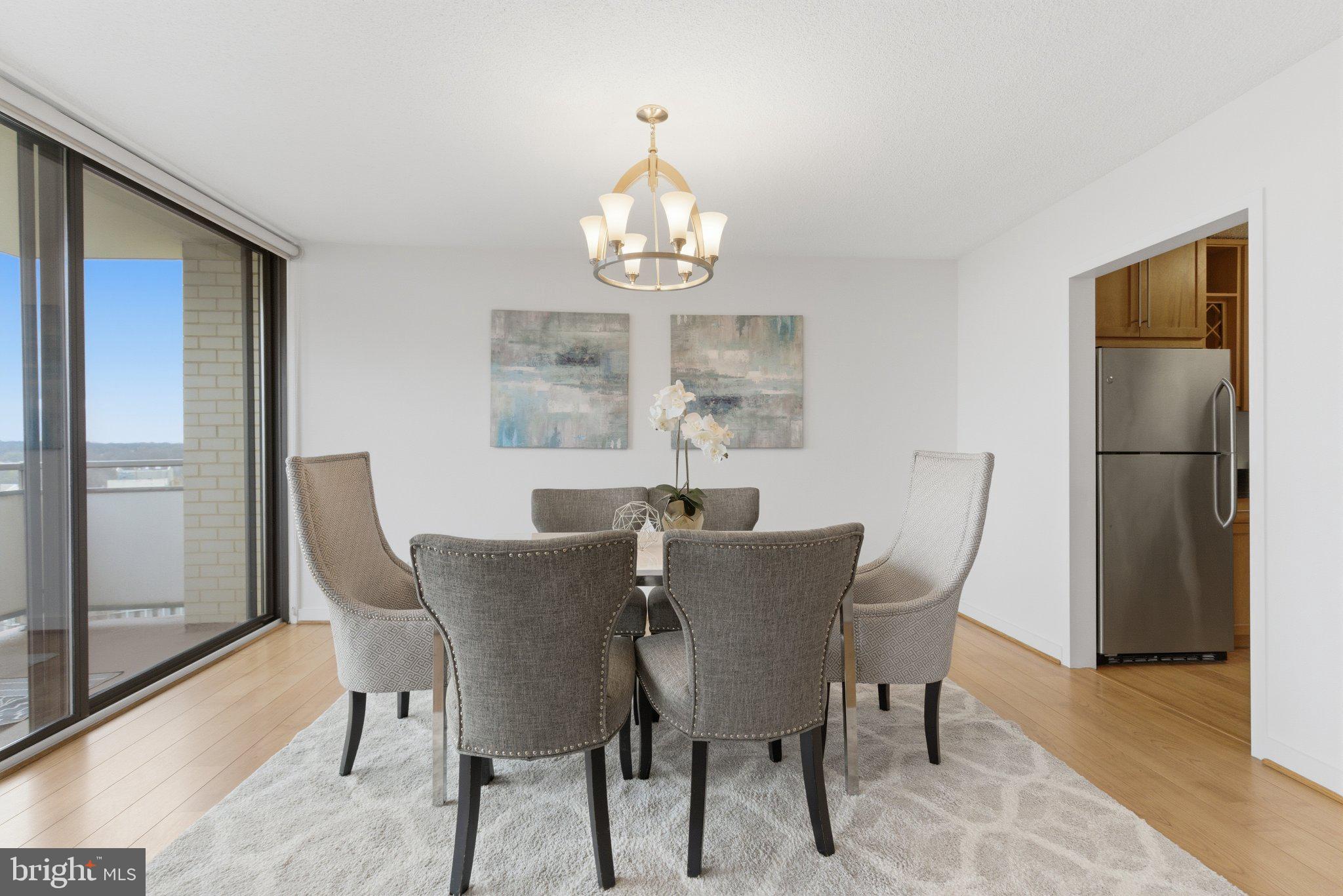 5225 Pooks Hill Road, Unit 1323S Bethesda, MD 20814 - Photo 12 of 39 a view of a dining room with furniture a chandelier and wooden floor