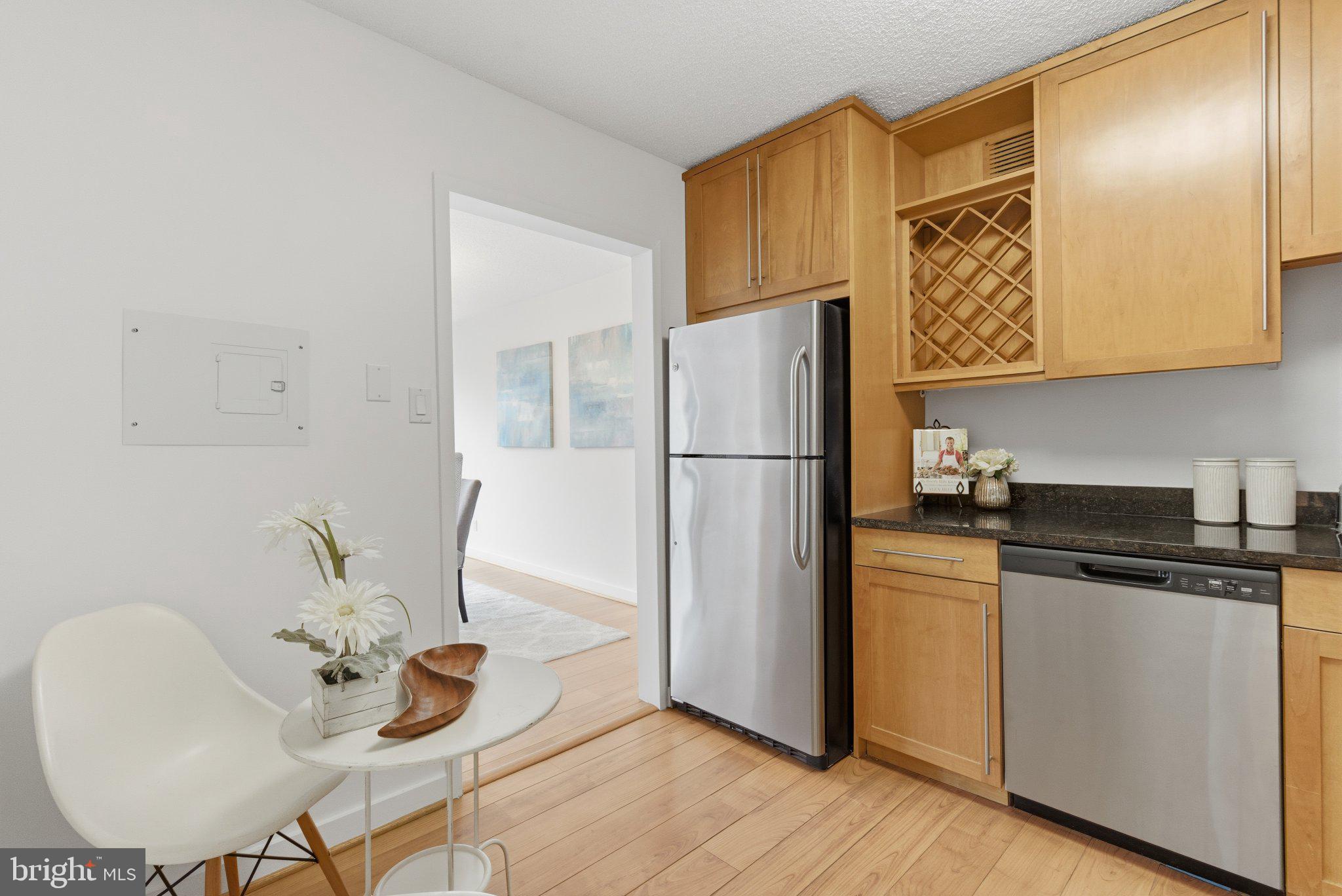5225 Pooks Hill Road, Unit 1323S Bethesda, MD 20814 - Photo 17 of 39 a kitchen with stainless steel appliances granite countertop a refrigerator a stove and a dining table with wooden floor
