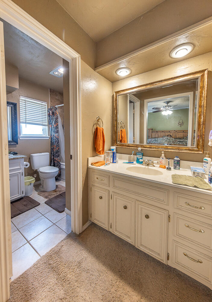 6 Ridge Road Ransom Canyon, TX 79366 - Photo 15 of 31 a spacious bathroom with a double vanity sink a mirror and a toilet
