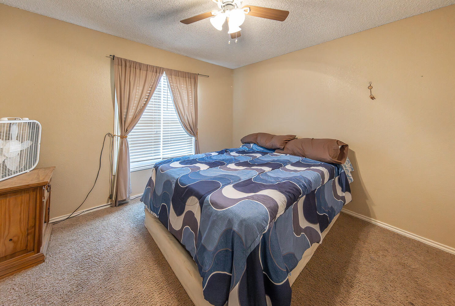 6 Ridge Road Ransom Canyon, TX 79366 - Photo 20 of 31 a bedroom with a bed and a chandelier