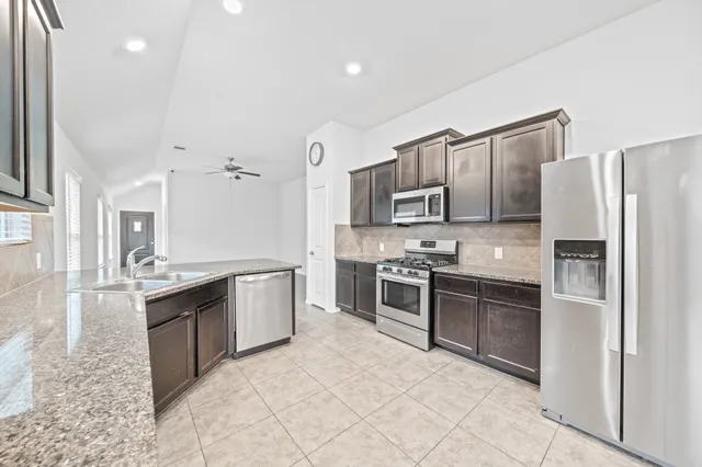 a large kitchen with a stove top oven and refrigerator