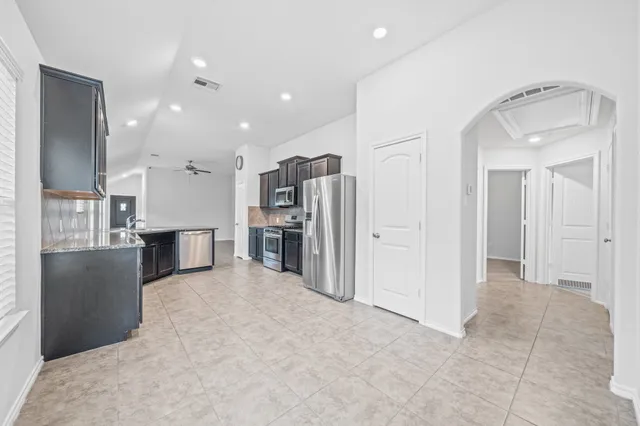a view of a kitchen with refrigerator and a sink