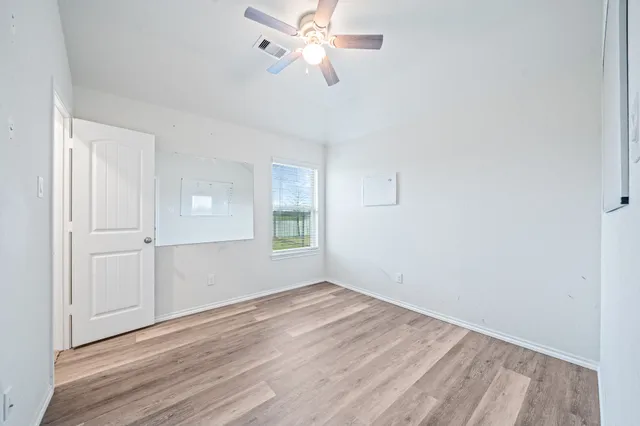 wooden floor in an empty room with a window