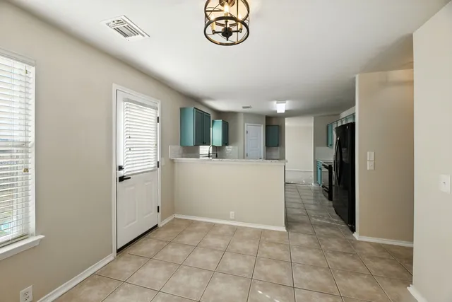 an empty room with windows and fan