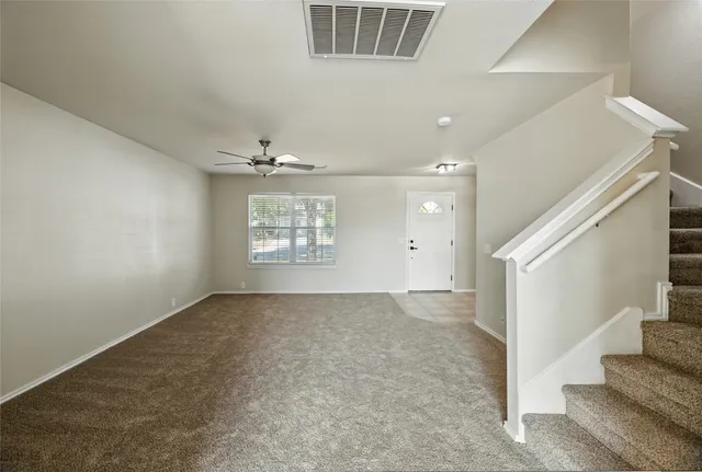 a view of a room with a empty space and a ceiling fan