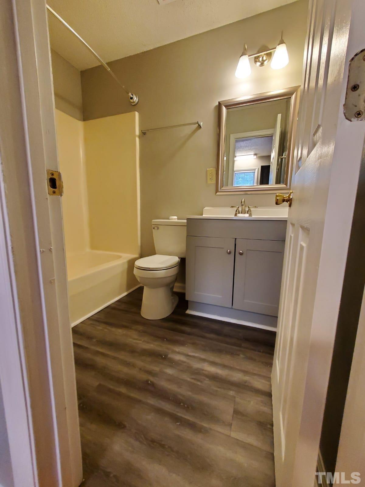 1011 Morreene Road, Unit 11 Durham, NC 27705 - Photo 4 of 5 a bathroom with a sink a toilet and mirror